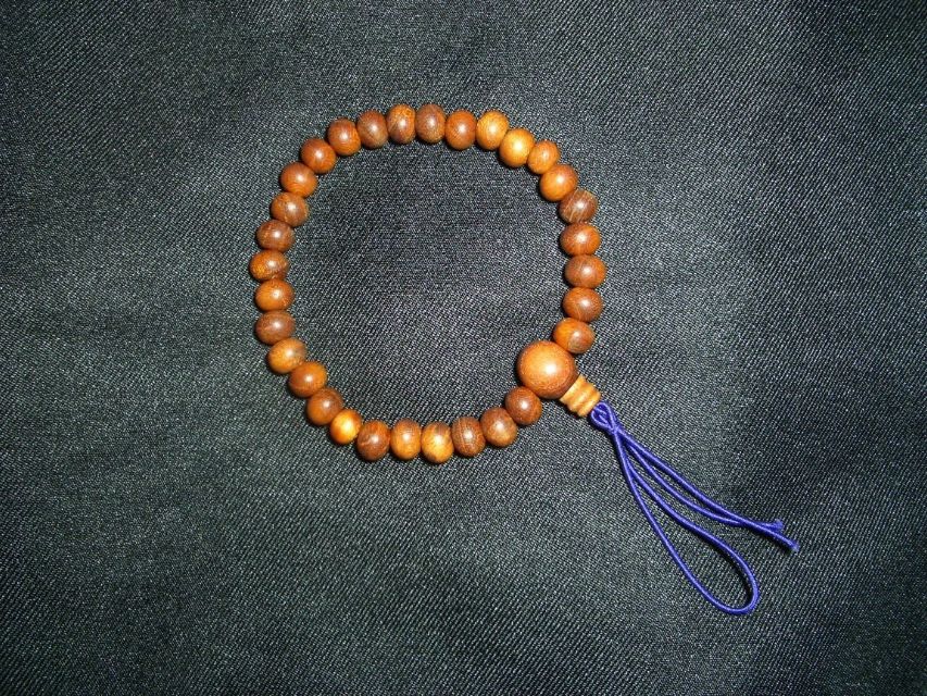 A simple Buddhist rosary, with the reminder string emerging from a sober stūpa bead - wikicommons.jpeg