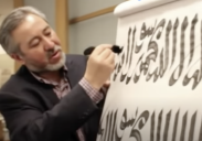 Fig 17:  The master calligrapher, Haji Noor Deen, demonstrates one of the ways bism Allah (in the name of God) can be written in Chinese-style Arabic script, using a broad wooden brush, Harvard University, 2012 - [screenshot from the video: Arabic Calligraphy in the Chinese Tradition — Haji Noor Deen Studio](https://youtu.be/TzzZhN1hJe4 ), (accessed 10/08/2021).