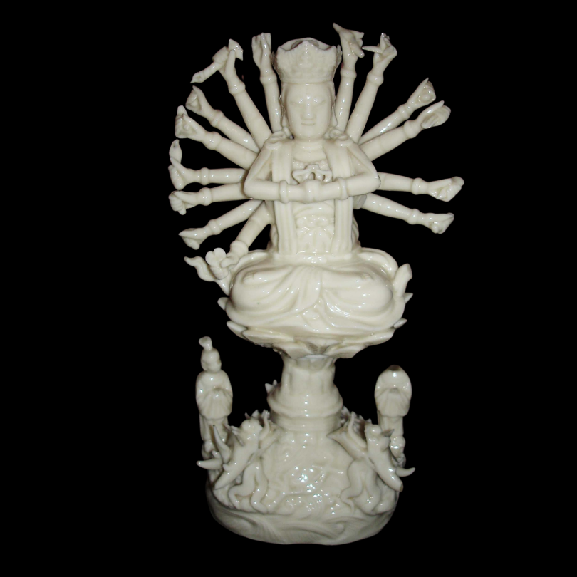 Figure of Guanyin, many-armed, seated on a lotus pedestal. Made of Blanc de Chine porcelain. - The Trustees of the British Museum - 956878001.png