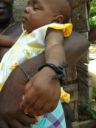 Baby with bracelet of twisted dark blue fabric around her wrist, which wards off the evil eye - [Bushblogsuriname](https://bushblogsuriname.files.wordpress.com/2013/07/armbandje-tegen-het-boze-oog-foto-t-vossen1.jpg?w=520&h=694)