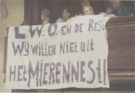 Fig. 1. Visitors of the community center brought a banner to a city council meeting to demonstrate against shutting down Het Mierennest. The banner reads: “L.W.O. and the rest, we don’t want to leave Het Mierennest!” – Mark Lamers – [Leidsch Dagblad 05-07-2000](https://leiden.courant.nu/issue/LD/2000-07-05/edition/0/page/11)